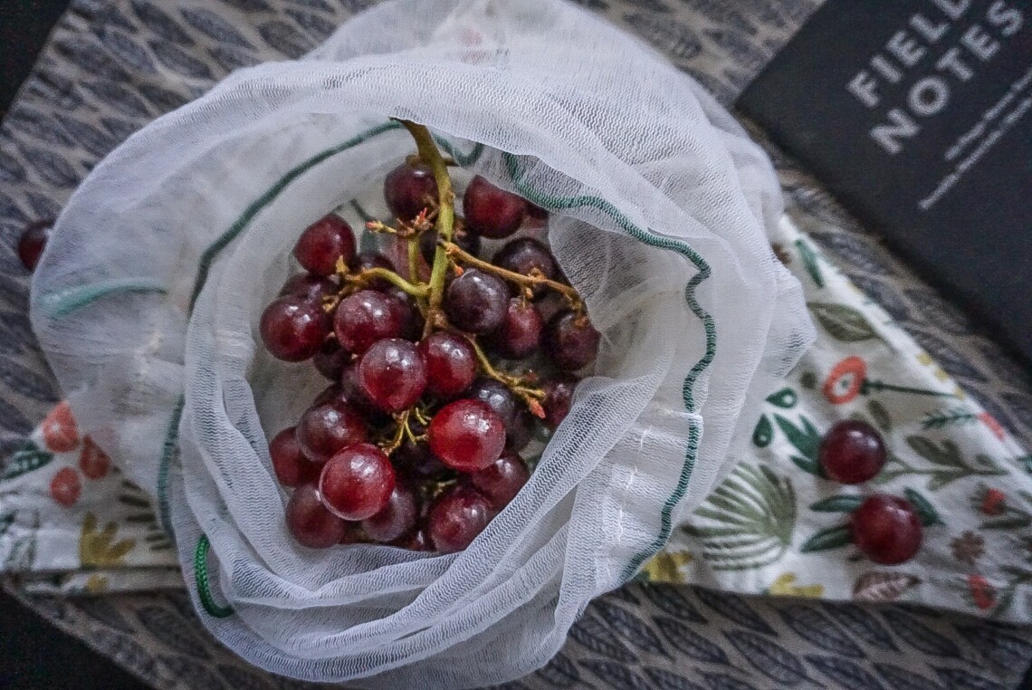 red grapes in a mesh produce bag on top of a napkin