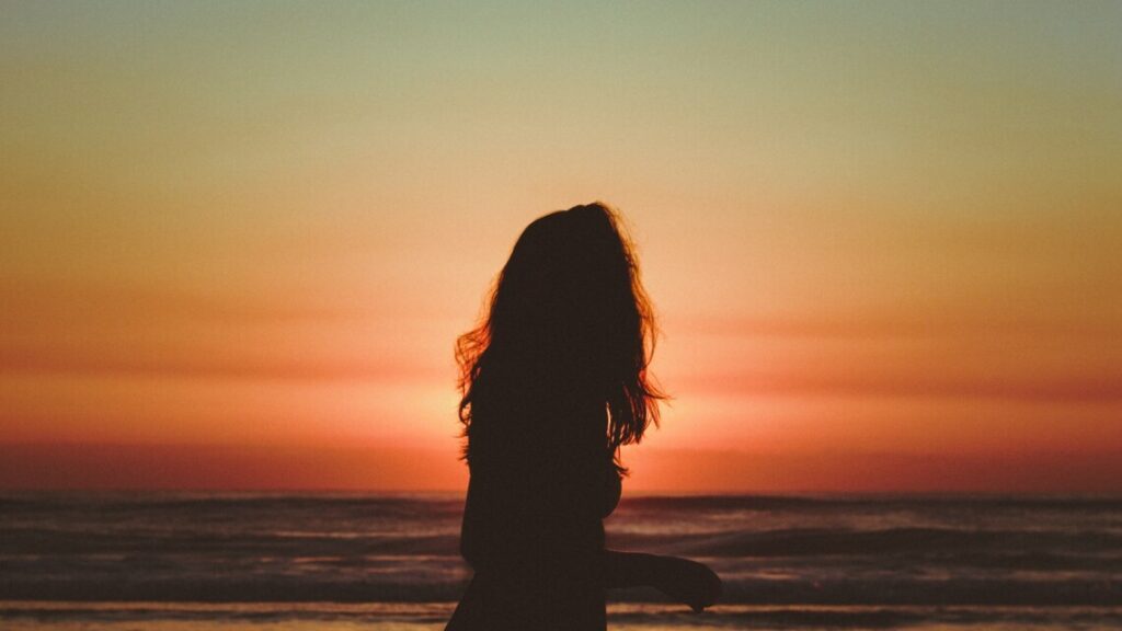 silhouet of a girl on the beach during sunset