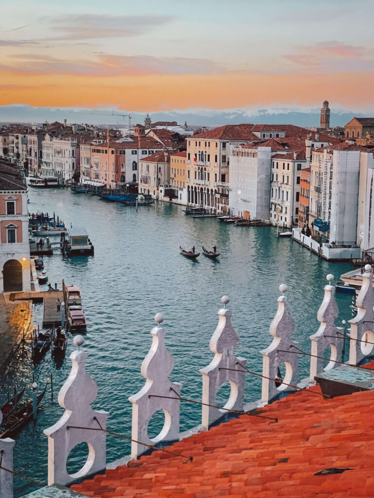 Aerial view of the Venice Grand Calan at sunset with two gondolas floating down the canal
