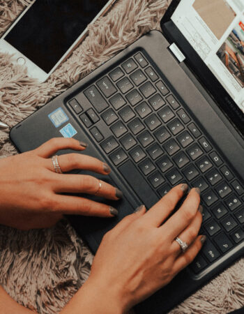 A woman's hands are typing on a laptop while browsing Pinterest keywords