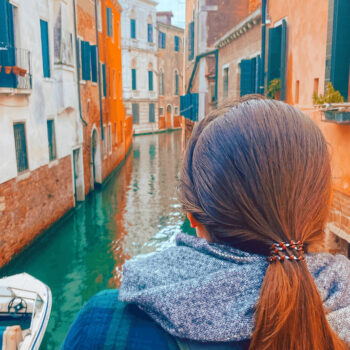 A woman looking into a Venice canal