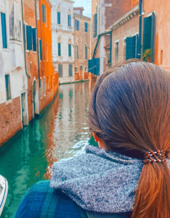 A woman looking into a Venice canal